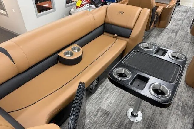 Slide: The Image of 2023 Avalon Catalina 2585 QL interior with tan seating and a table featuring cup holders. - 23