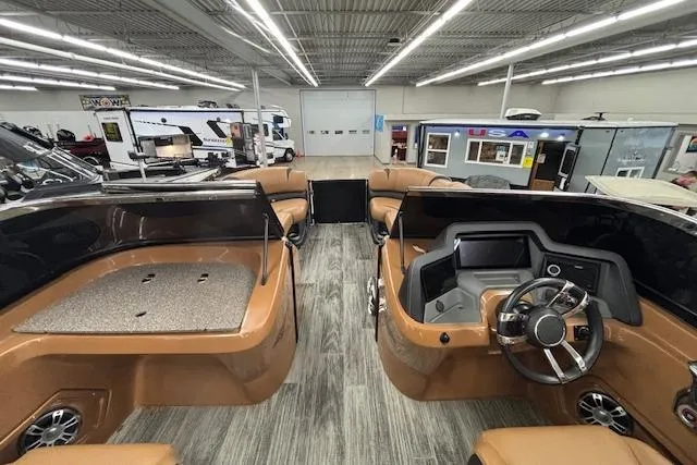 Slide: The Image of 2023 Avalon Catalina 2585 QL boat interior with modern dashboard and seating in showroom. - 25