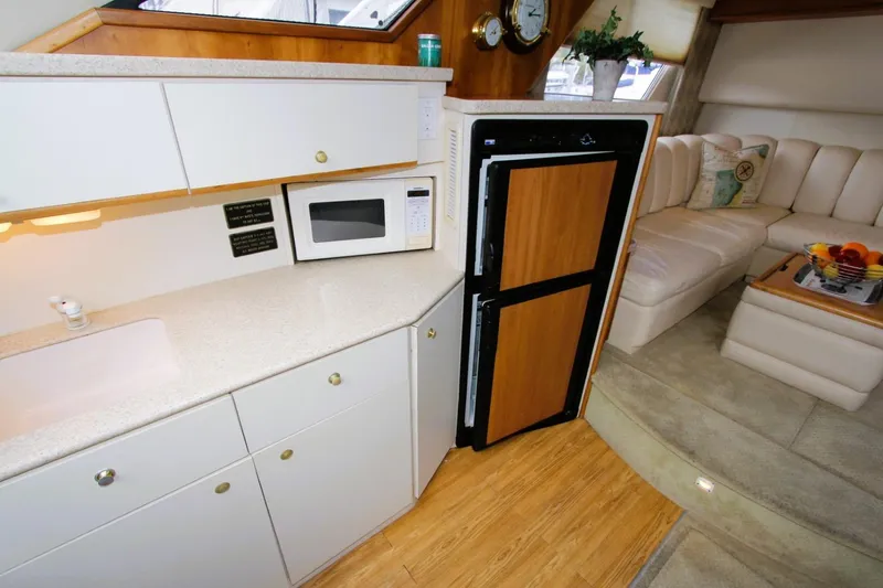 Slide: The Image of 1998 Silverton 372 Motor Yacht interior with kitchenette and seating area. - 10