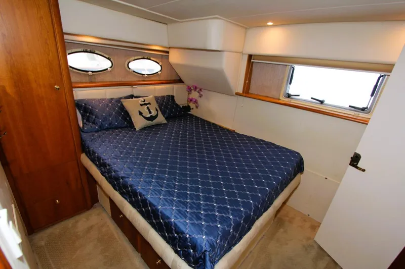 Slide: The Image of Luxurious bedroom in 1998 Silverton 372 Motor Yacht with nautical decor and porthole windows. - 18