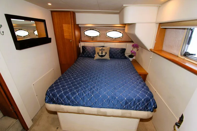 Slide: The Image of 1998 Silverton 372 Motor Yacht bedroom with blue bedding and nautical decor. - 19