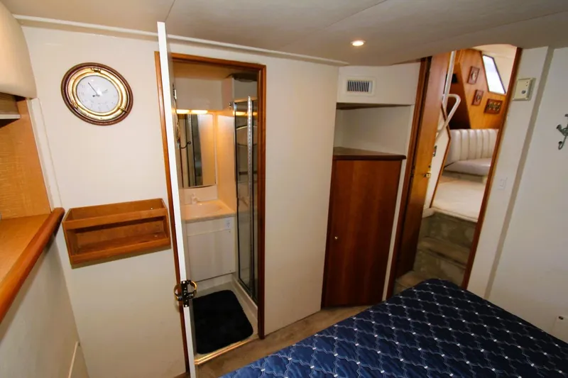 Slide: The Image of 1998 Silverton 372 Motor Yacht interior with bedroom, bathroom, and wooden cabinetry. - 20