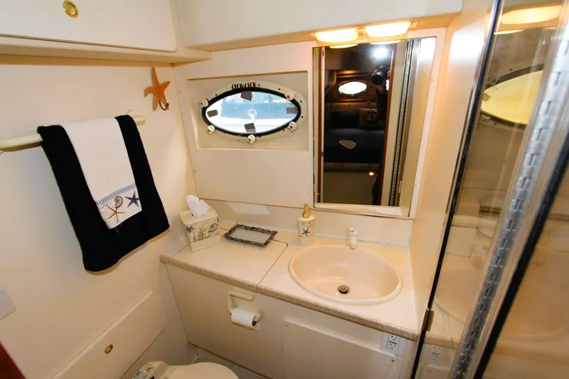 Slide: The Image of Bathroom interior of 1998 Silverton 372 Motor Yacht, featuring sink, mirror, and nautical decor. - 21