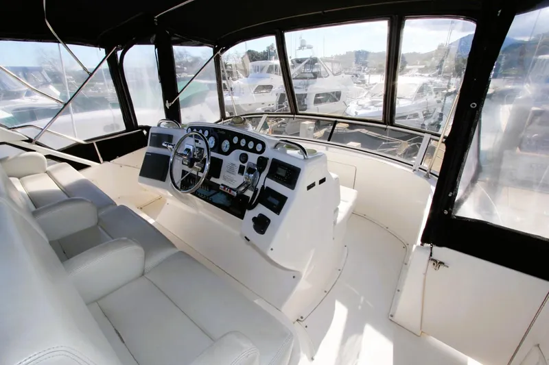 Slide: The Image of 1998 Silverton 372 Motor Yacht helm with white seating and panoramic windows. - 29