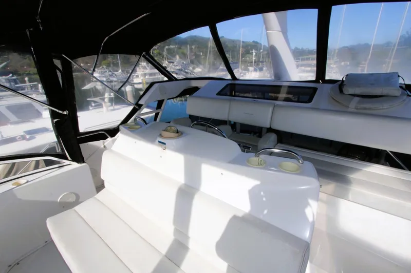 Slide: The Image of 1998 Silverton 372 Motor Yacht interior with seating and helm, docked at marina. - 31