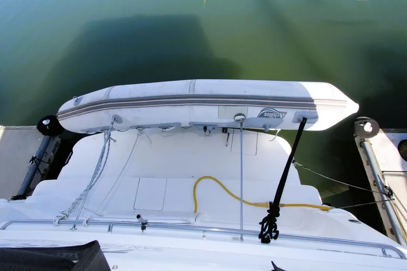 Slide: The Image of 1998 Silverton 372 Motor Yacht with dinghy, docked on calm water. - 32