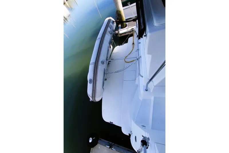 Slide: The Image of 1998 Silverton 372 Motor Yacht with attached dinghy at dockside. - 33