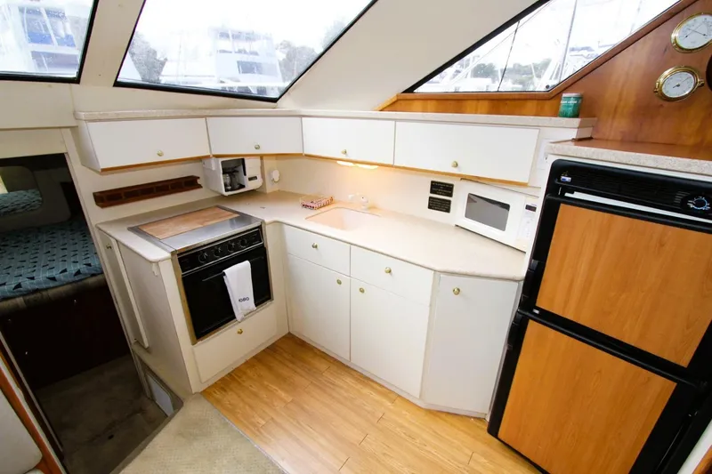 Slide: The Image of 1998 Silverton 372 Motor Yacht kitchen with modern appliances and wood accents. - 8