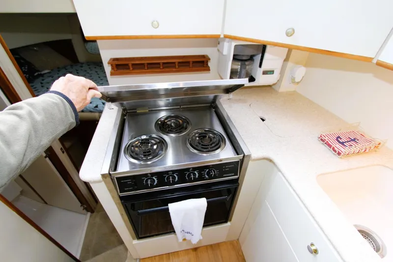 Slide: The Image of 1998 Silverton 372 Motor Yacht kitchen with stove, countertop, and sink. - 9