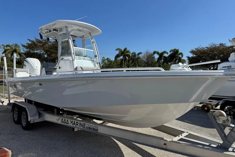 Slide: The Image of 2024 Everglades 243 Center Console boat on trailer, parked outdoors under clear sky. - 12