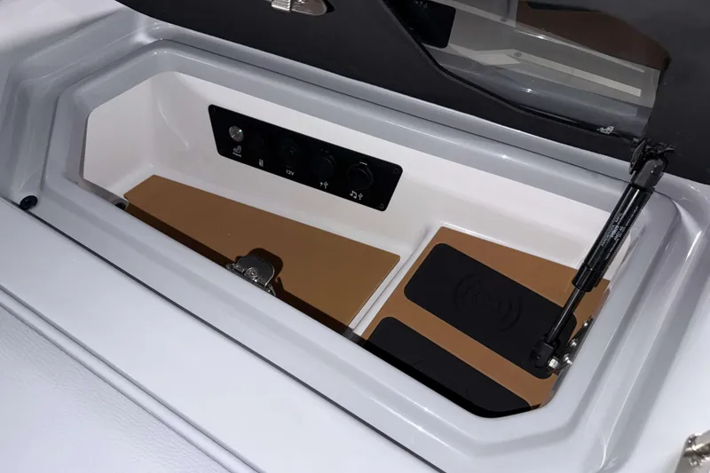Slide: The Image of 2026 Nautique Super Air Nautique G23 storage compartment with control panel and wireless charging pad. - 26