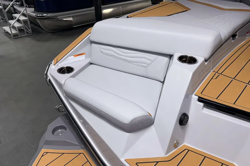Slide: The Image of 2026 Nautique Super Air Nautique G23 boat interior with cushioned seating and cup holders. - 3