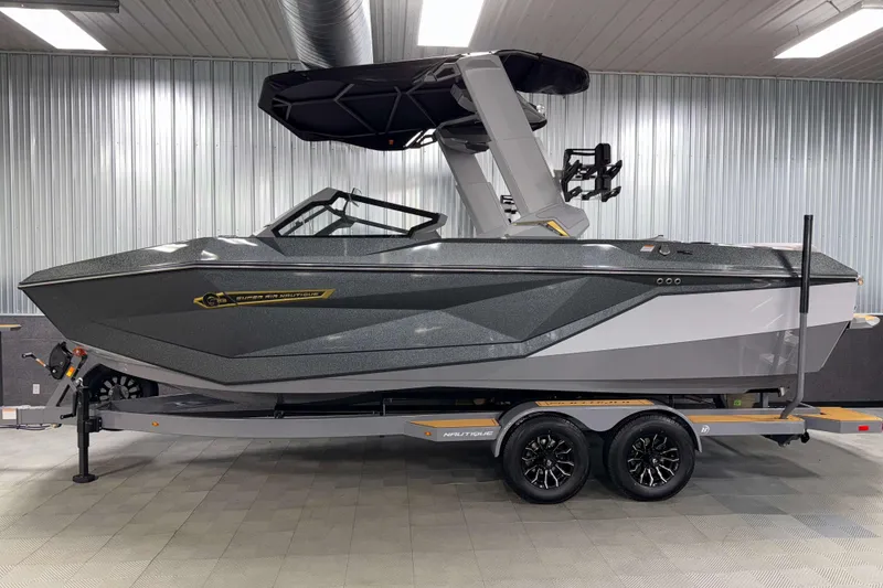 Slide: The Image of 2026 Nautique Super Air Nautique G23 boat in showroom, sleek design, on trailer. - 50