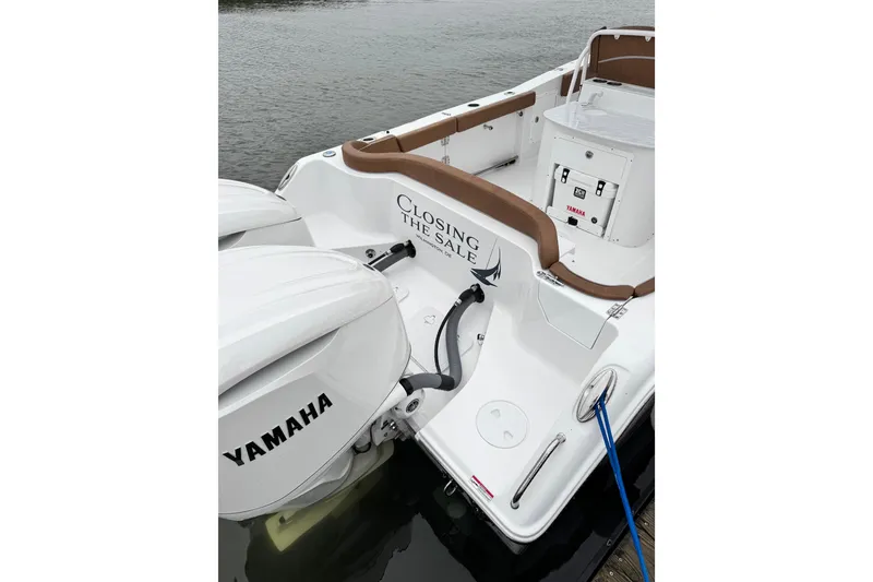 Slide: The Image of 2025 Sea Hunt Ultra 305 SE boat with Yamaha engines docked by the water. - 7