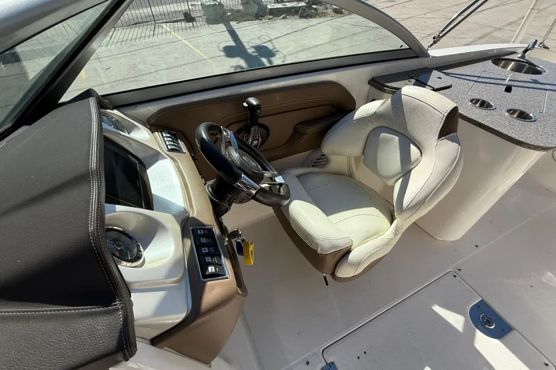 Slide: The Image of 2014 Chaparral 264 Sunesta boat cockpit with steering wheel and control panel. - 12