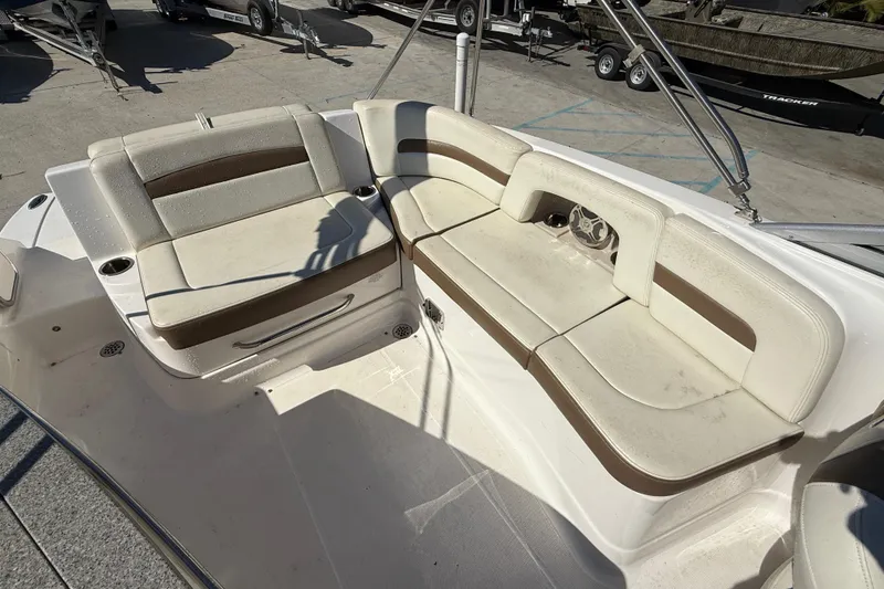 Slide: The Image of 2014 Chaparral 264 Sunesta boat interior with beige seating and cup holders. - 13