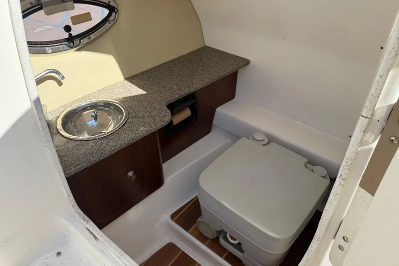 Slide: The Image of 2014 Chaparral 264 Sunesta boat interior with sink and portable toilet. - 18