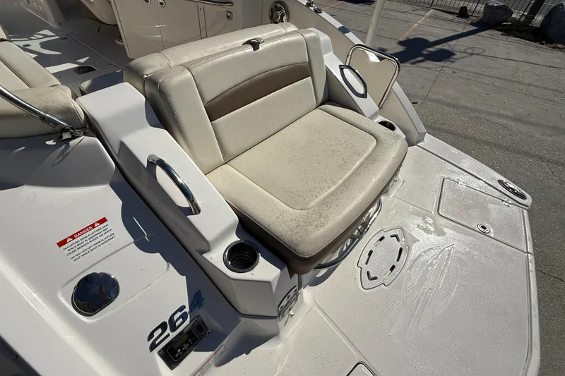 Slide: The Image of 2014 Chaparral 264 Sunesta boat seat with cup holders and safety warning label. - 20