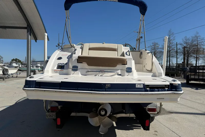 Slide: The Image of 2014 Chaparral 264 Sunesta boat rear view, parked outdoors under clear blue sky. - 6