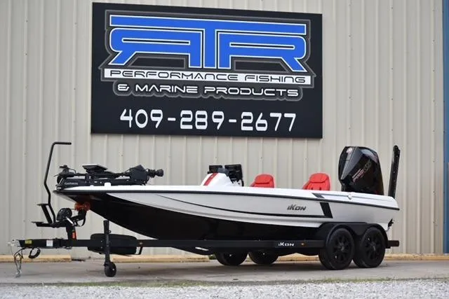 The Image of 2024 iKon LX21 fishing boat on trailer, displayed outside marine products store. - 0