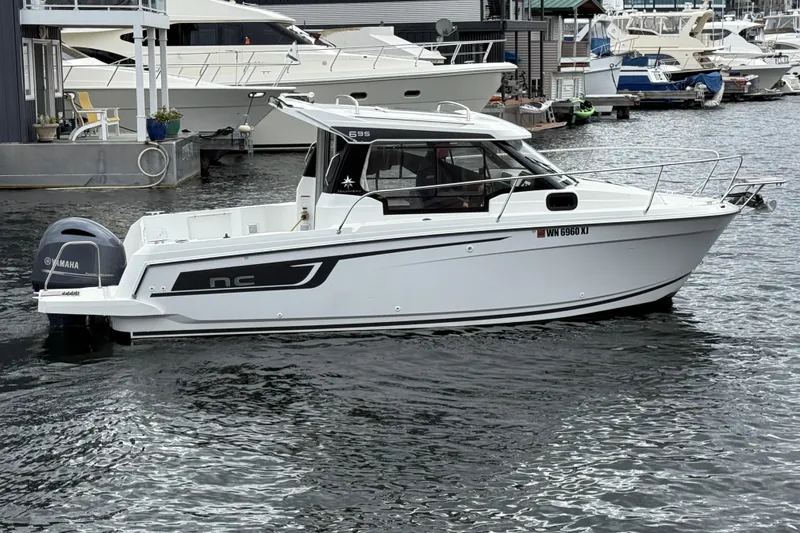 The Image of 2024 Jeanneau NC 695 Sport boat on water, side view, with Yamaha engine. - 0