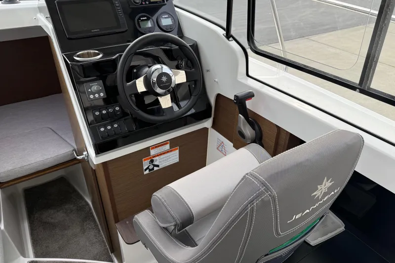 Slide: The Image of 2024 Jeanneau NC 695 Sport boat cockpit with steering wheel and control panel. - 10