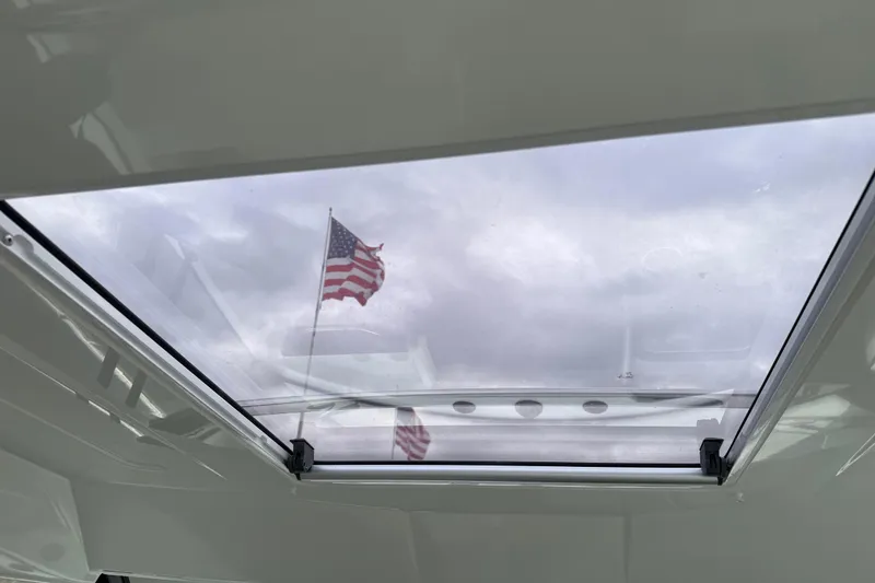 Slide: The Image of 2024 Jeanneau NC 695 Sport boat skylight with American flag view. - 17