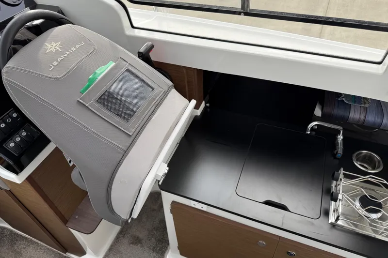 Slide: The Image of 2024 Jeanneau NC 695 Sport interior helm and kitchenette view. - 21