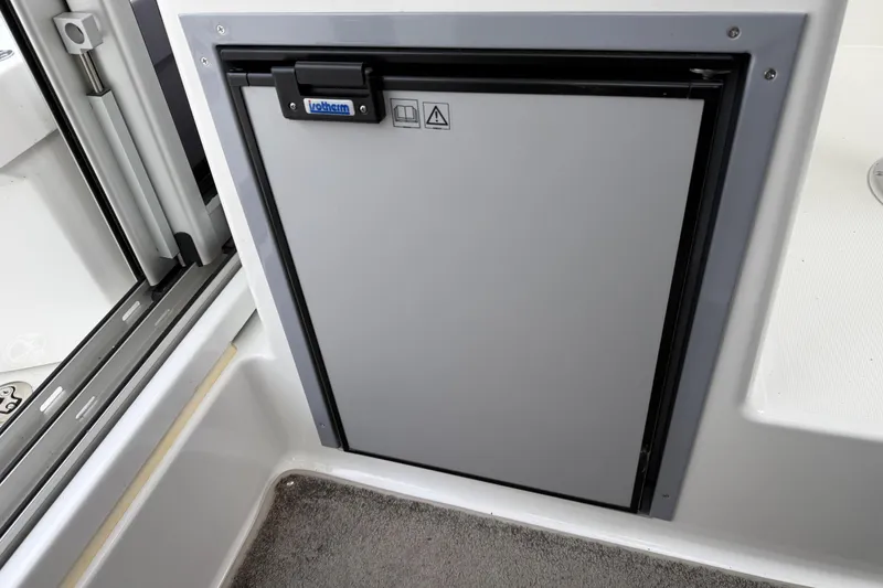 Slide: The Image of 2024 Jeanneau NC 695 Sport interior with compact refrigerator. - 22