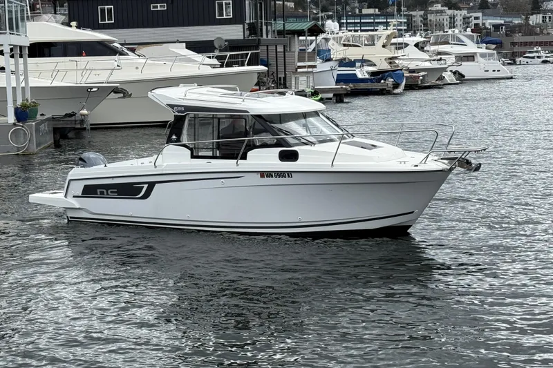 Slide: The Image of 2024 Jeanneau NC 695 Sport boat docked in a marina setting. - 3