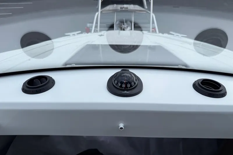 Slide: The Image of 2024 Jeanneau NC 695 Sport dashboard with compass and ventilation controls. - 35