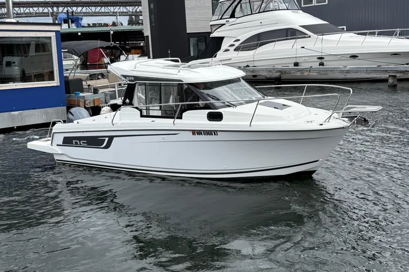 Slide: The Image of 2024 Jeanneau NC 695 Sport boat docked in marina, side view. - 4