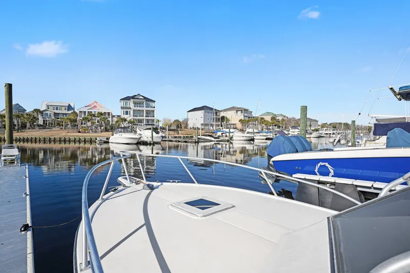 Slide: The Image of Albemarle 28 Express 2002 in scenic harbor with houses in background. - 20