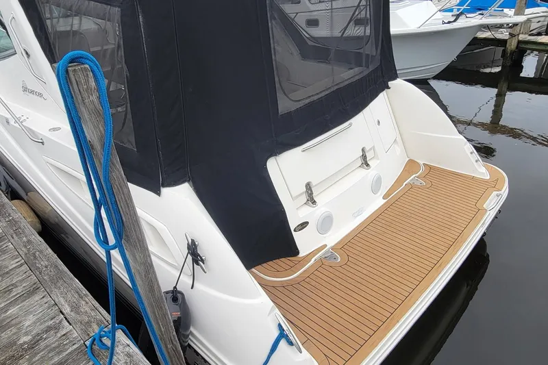 Slide: The Image of 2008 Sea Ray Sundancer 330 docked, featuring a teak swim platform and black canvas cover. - 3