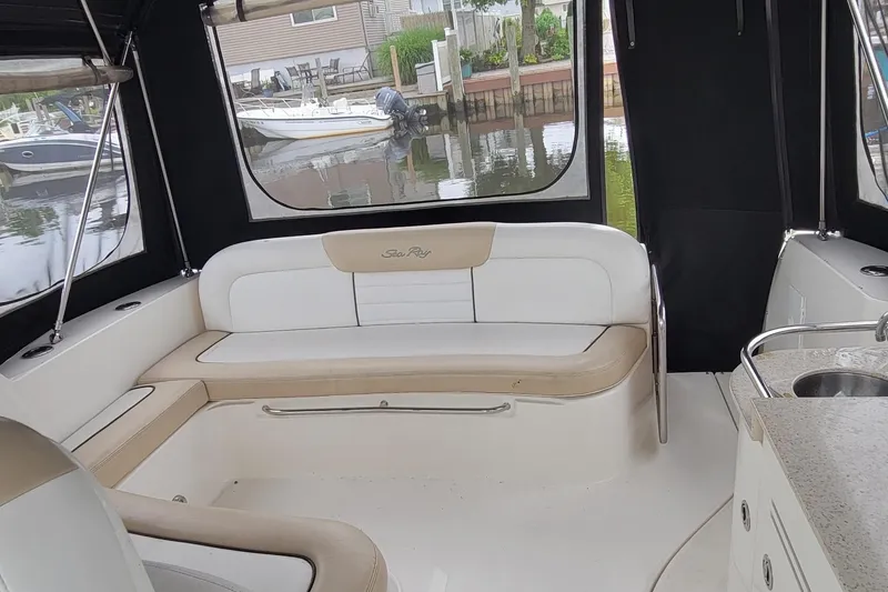 Slide: The Image of 2008 Sea Ray Sundancer 330 interior with seating and kitchenette, docked by the water. - 8