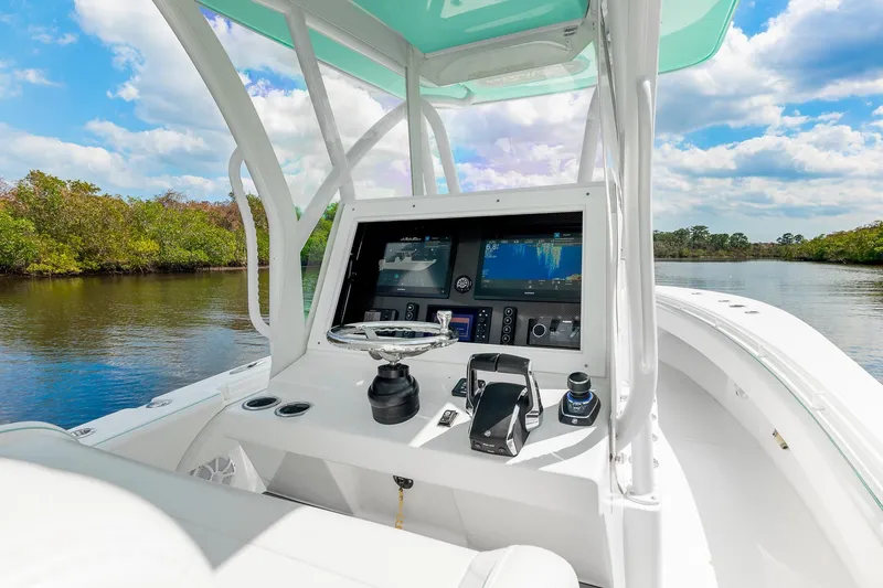 Slide: The Image of 2024 SeaHunter 28 Floridian boat console with advanced navigation system on a scenic waterway. - 11