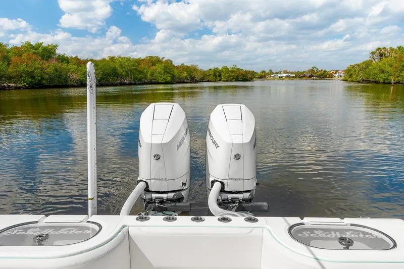 Slide: The Image of 2024 SeaHunter 28 Floridian boat with dual Mercury outboard engines on a calm river. - 13