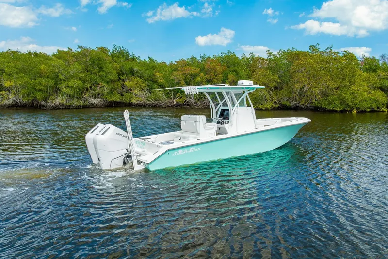 Slide: The Image of 2024 SeaHunter 28 Floridian boat cruising on a scenic waterway with lush greenery. - 2