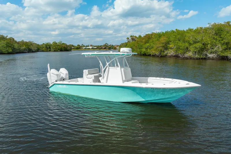 Slide: The Image of 2024 SeaHunter 28 Floridian boat on calm water, clear sky, lush greenery. - 3