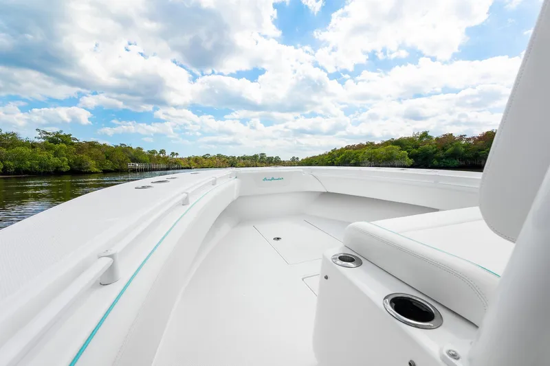 Slide: The Image of 2024 SeaHunter 28 Floridian boat interior with lush riverbank and cloudy sky backdrop. - 4