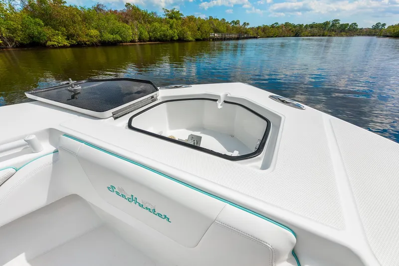 Slide: The Image of 2024 SeaHunter 28 Floridian boat interior with open hatch, on a serene river. - 6