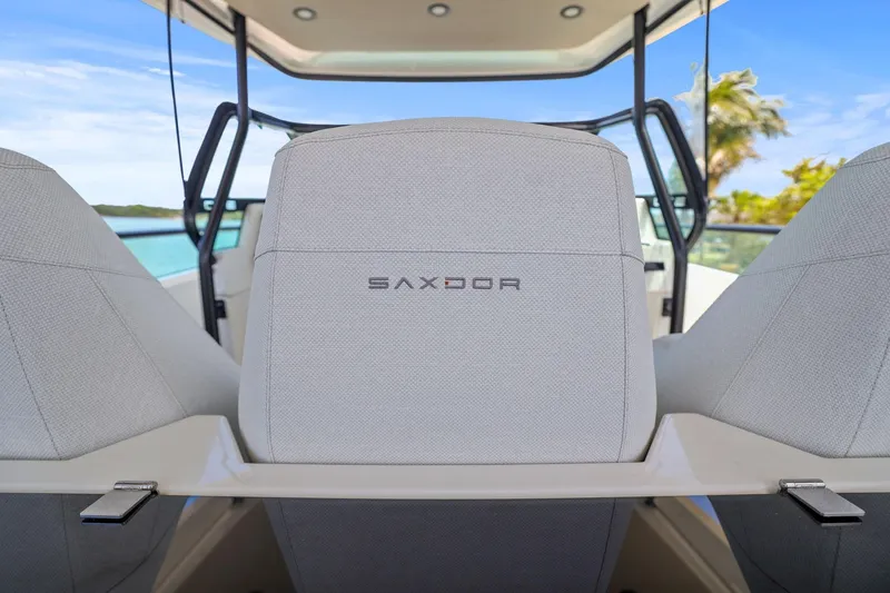 Slide: The Image of 2025 Saxdor 320 GTO boat interior with branded seating, ocean view background. - 17