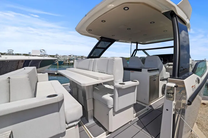Slide: The Image of 2025 Saxdor 320 GTO luxury boat interior with seating and helm, docked at marina. - 25