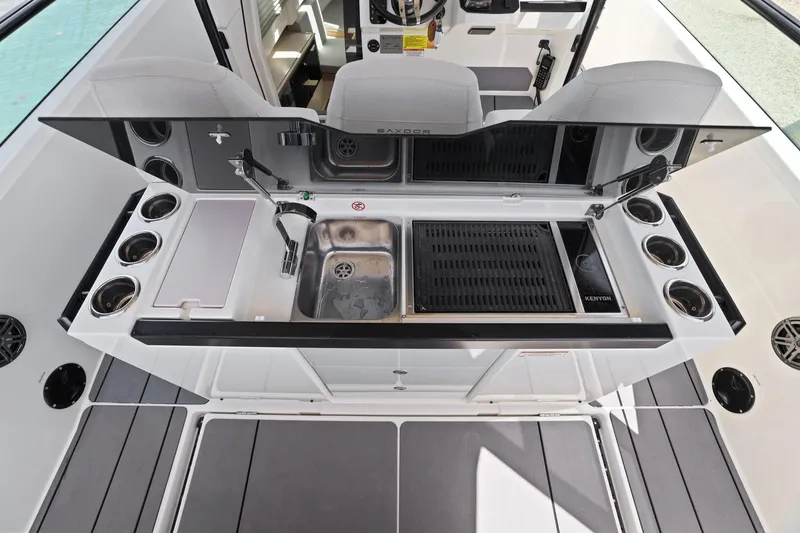 Slide: The Image of 2025 Saxdor 320 GTO boat kitchen area with sink, grill, and cup holders. - 28