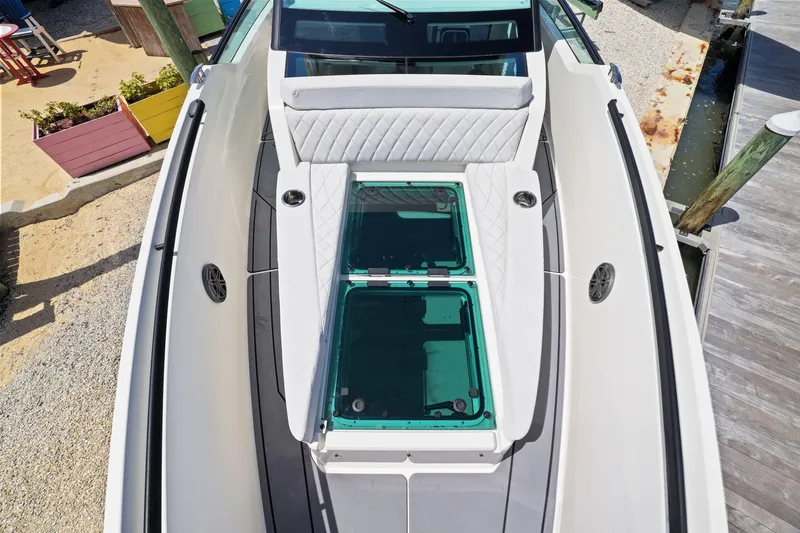 Slide: The Image of 2025 Saxdor 320 GTO boat deck with seating and glass panels, docked by the shore. - 38