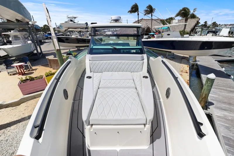 Slide: The Image of 2025 Saxdor 320 GTO boat with sleek design and luxurious seating at a marina. - 40