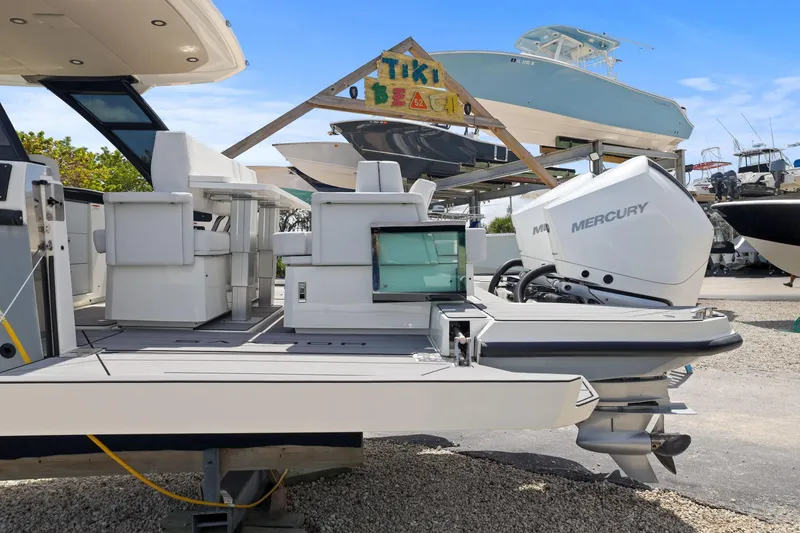 Slide: The Image of 2025 Saxdor 320 GTO boat with Mercury engine, displayed outdoors under clear blue sky. - 45