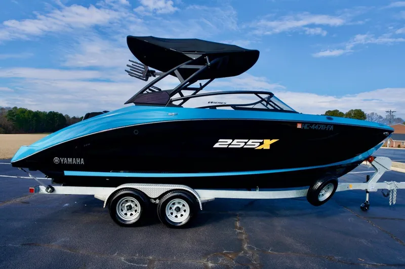 Slide: The Image of 2023 Yamaha Boats 255XD on trailer, sleek black and blue design, outdoor setting. - 3
