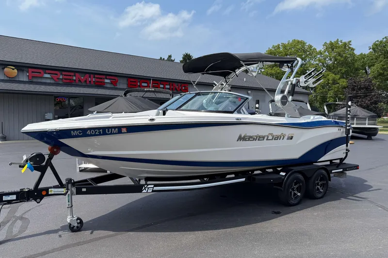 Slide: The Image of 2020 MasterCraft XT23 boat on trailer at Premier Boating dealership. - 21