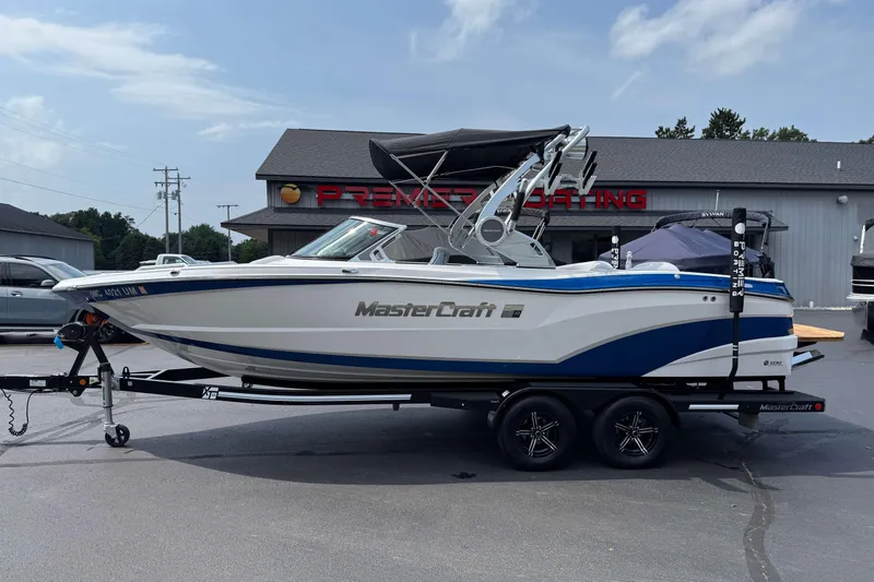 Slide: The Image of 2020 MasterCraft XT23 boat on trailer, parked outside dealership. - 23